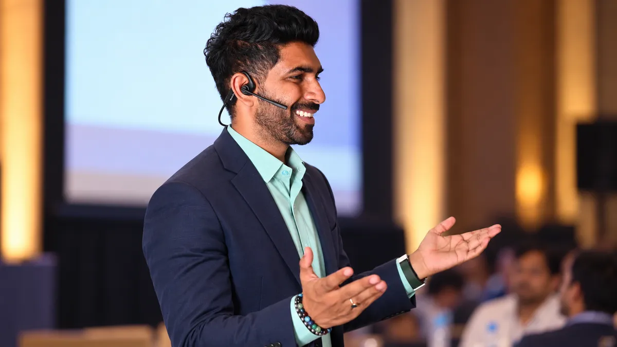 Coach Gireesh speaking on stage at a seminar